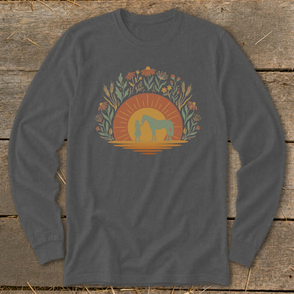 Long sleeve shirt with a silhouette of a person and horse against a sunset and floral design.