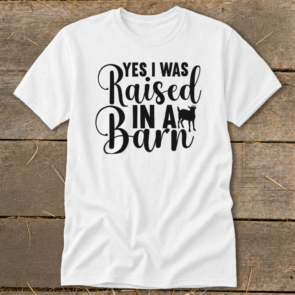 White t-shirt with black text that reads "YES I WAS Raised IN A Barn" and a goat silhouette.