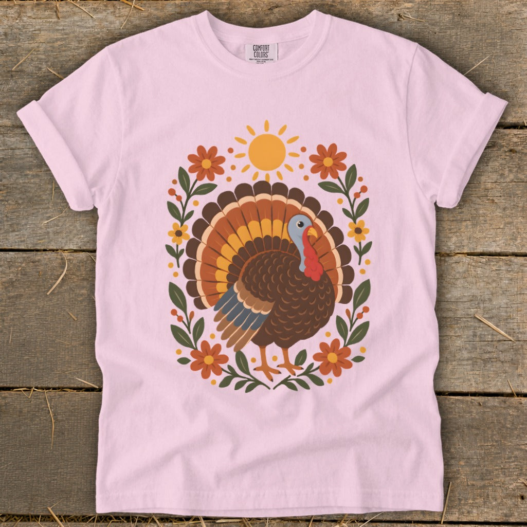 Pink t-shirt with a colorful turkey and floral design, "COMFORT COLORS" tag visible.