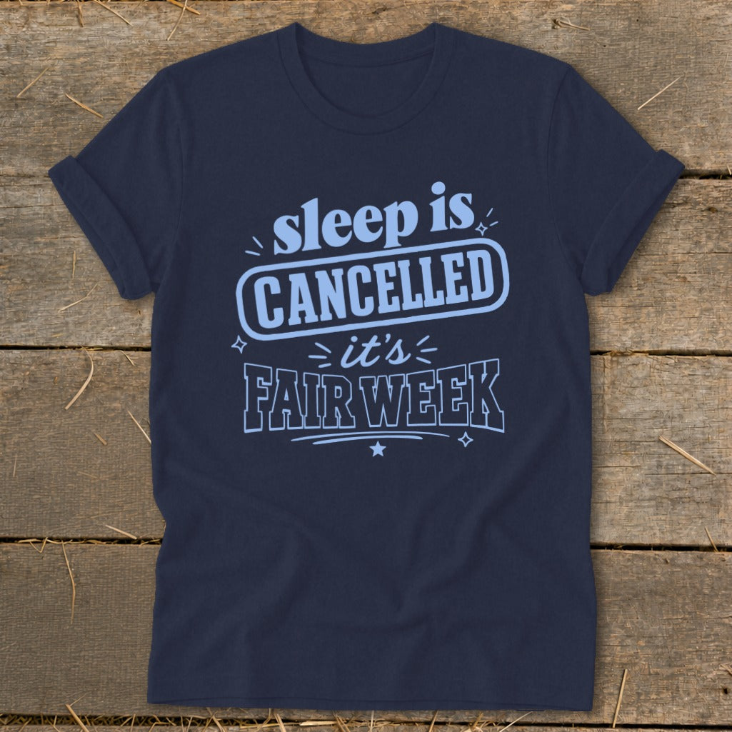 Navy t-shirt with light blue text reading "sleep is CANCELLED it's FAIR WEEK".