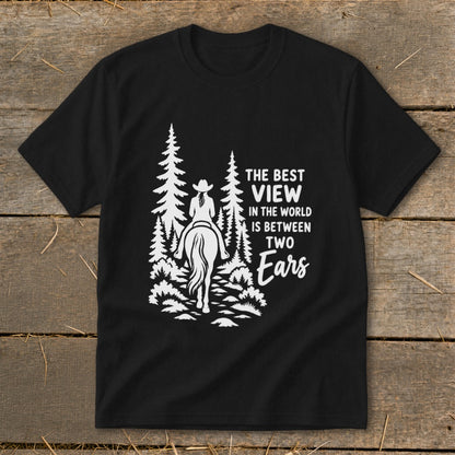 Black t-shirt featuring a white graphic of a horseback rider in the forest with text reading The Best View in the World is Between Two Ears.