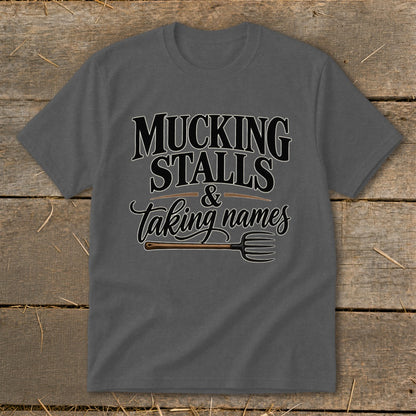 Grey t-shirt with "Mucking Stalls & Taking Names" text and a pitchfork graphic.