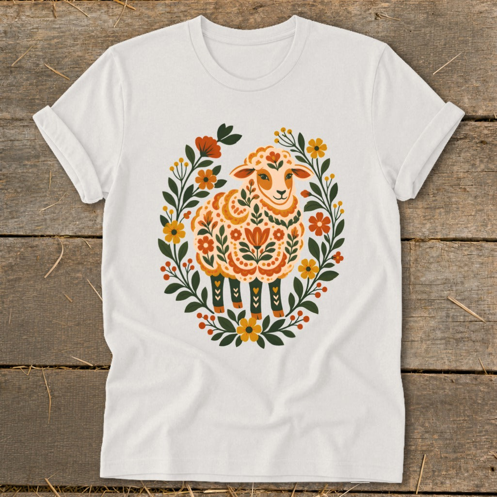 White t-shirt with a colorful folk art sheep surrounded by a floral wreath.