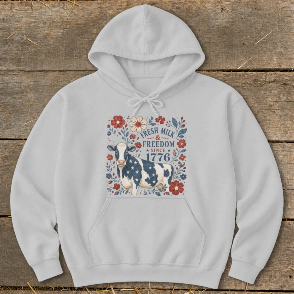 Light gray hoodie with a cow design and text "FRESH MILK & FREEDOM SINCE 1776".