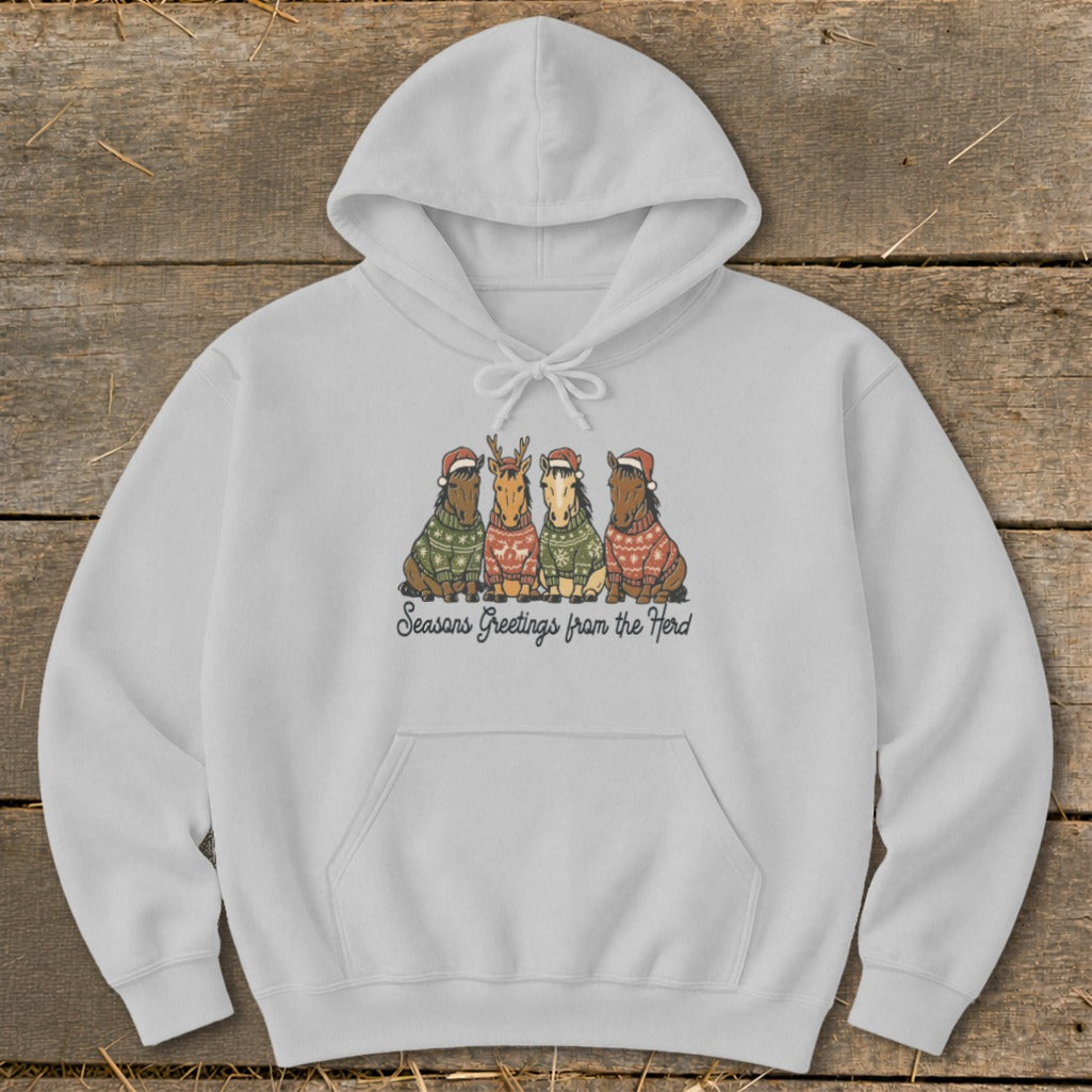 Light gray hoodie with four horses wearing Christmas sweaters and hats. Text reads "Seasons Greetings from the Herd."