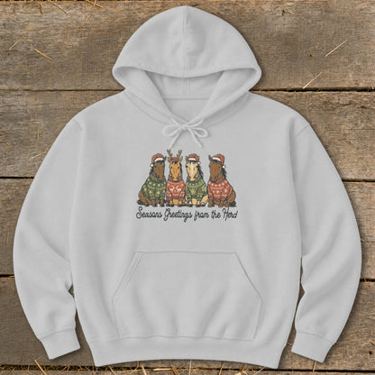 Light gray hoodie with four horses wearing Christmas sweaters and hats. Text reads "Seasons Greetings from the Herd."