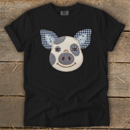 Black t-shirt with a stitched pig face appliques and checkered ears.