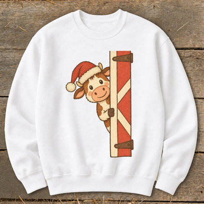 White sweatshirt with a cow wearing a Santa hat peeking from behind a barn door.