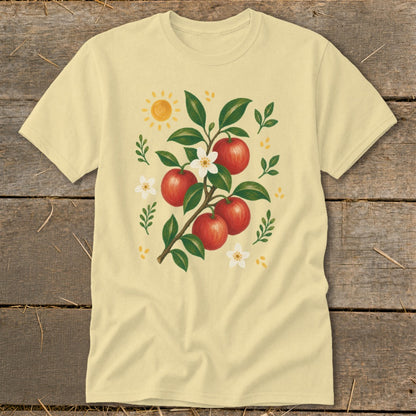 Light yellow t-shirt with a watercolor illustration of an apple branch with red apples, white blossoms, green leaves, and a sun.