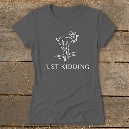 Grey t-shirt with white line drawing of a goat on fence posts, text reads "JUST KIDDING".