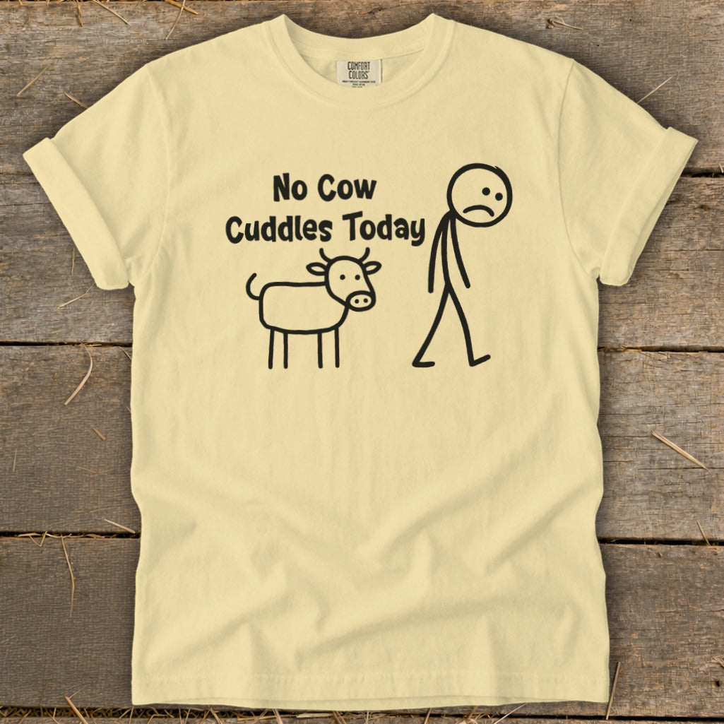 Light yellow t-shirt with "No Cow Cuddles Today" text and stick figures of cow and person.