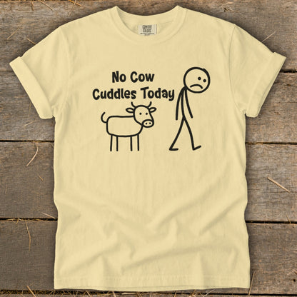 Light yellow t-shirt with "No Cow Cuddles Today" text and stick figures of cow and person.