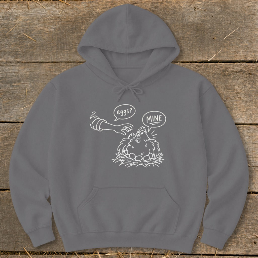 Grey hoodie with white graphic of a chicken protecting eggs, saying "MINE" while a hand asks "eggs?".