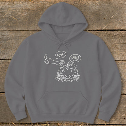 Grey hoodie with white graphic of a chicken protecting eggs, saying "MINE" while a hand asks "eggs?".