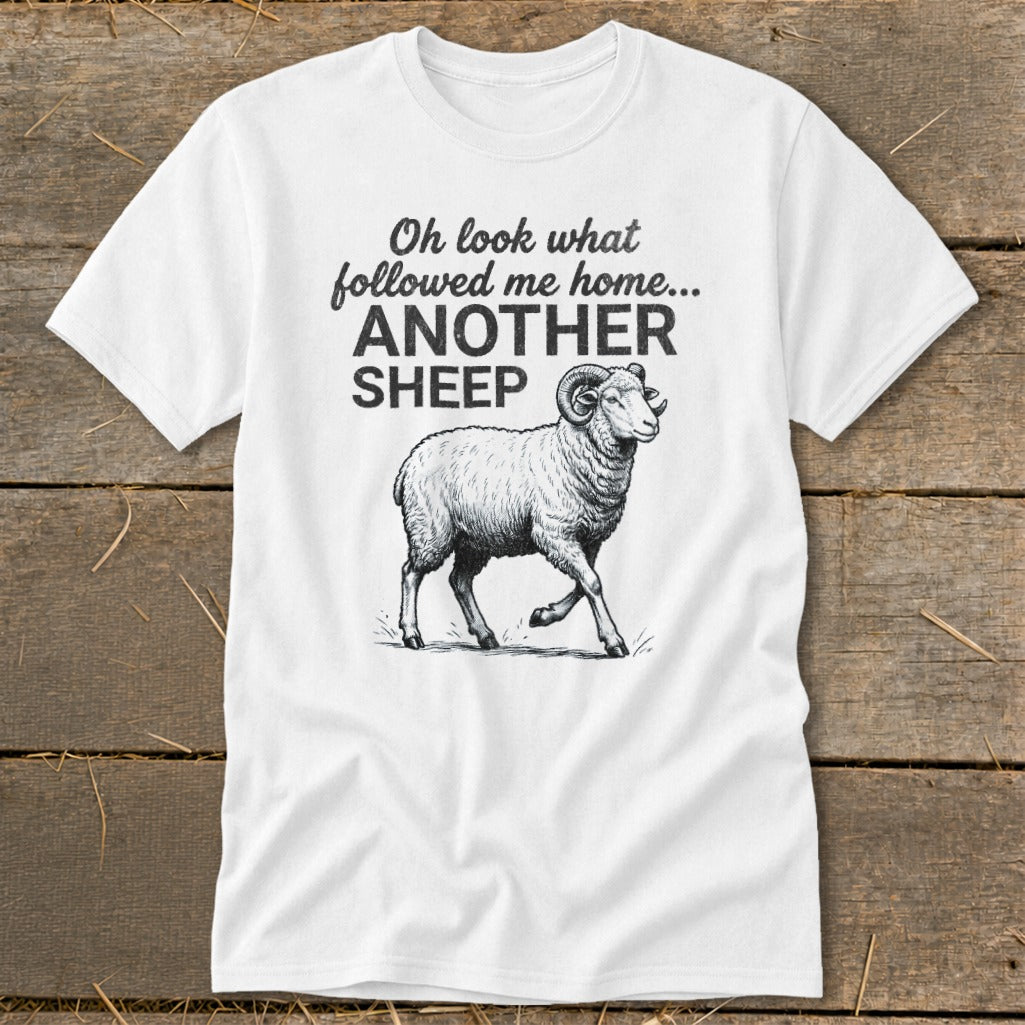 White t-shirt with black text and drawing of a ram, reads "Oh look what followed me home... ANOTHER SHEEP."
