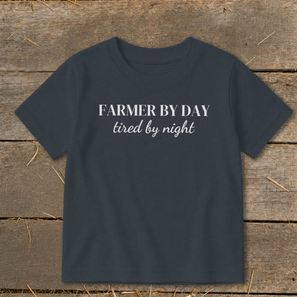 Dark gray t-shirt with white text "FARMER BY DAY tired by night".