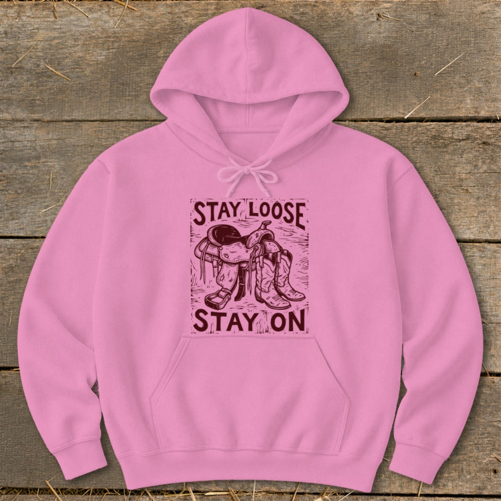 Pink hoodie with "STAY LOOSE STAY ON" text and western saddle and boots graphic.