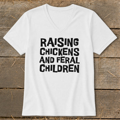 White v-neck t-shirt with black text reading "RAISING CHICKENS AND FERAL CHILDREN".