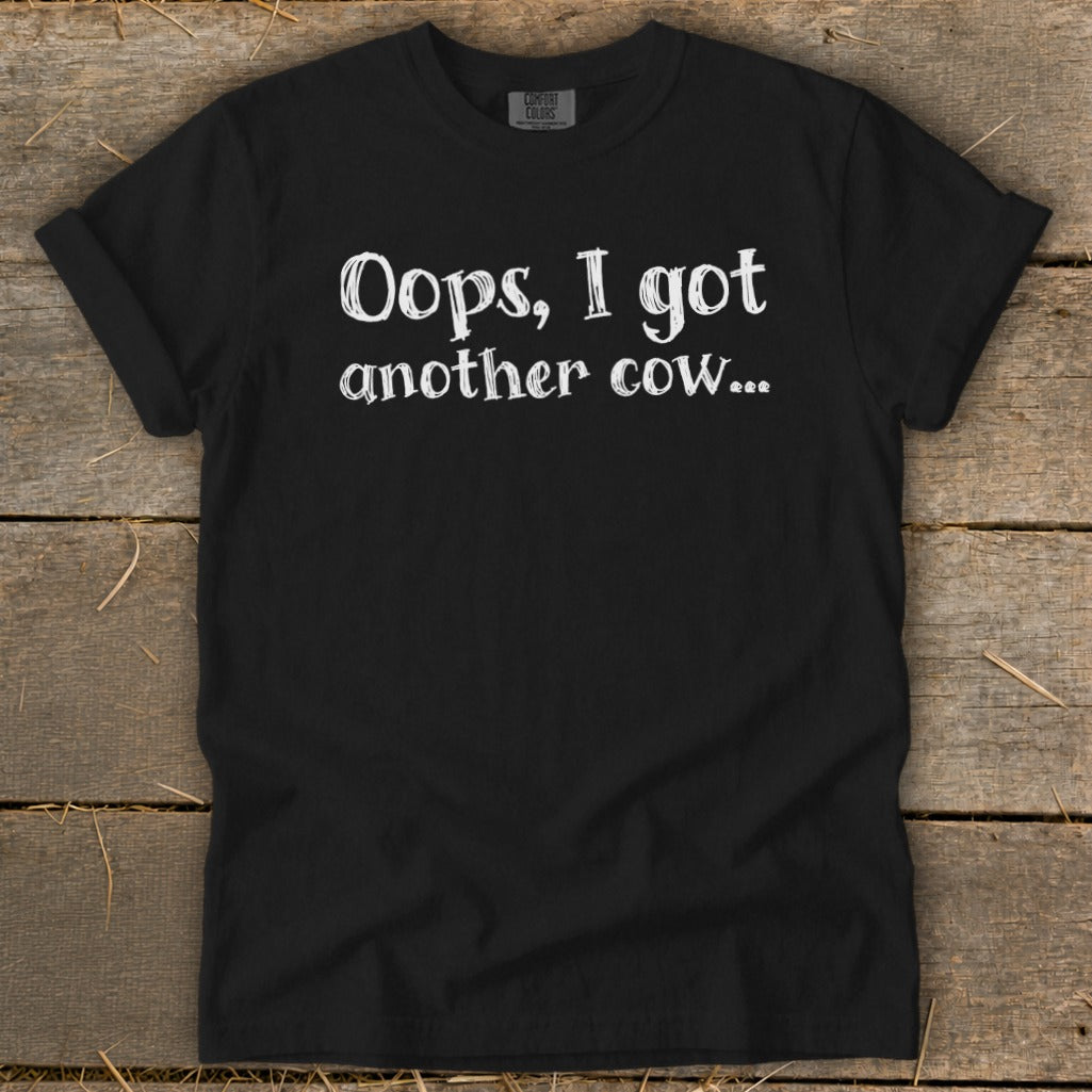 Black t-shirt with white text that reads "Oops, I got another cow..."