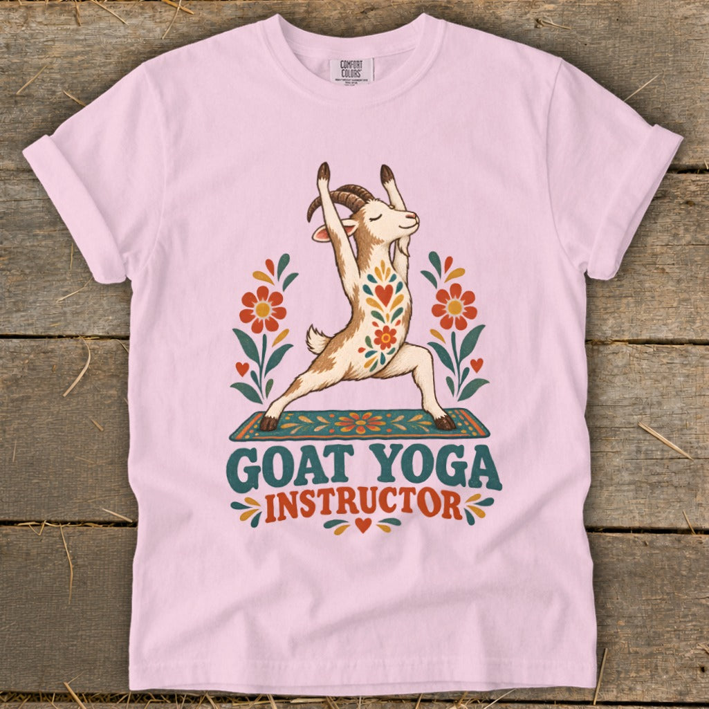 Pink t-shirt with a goat doing yoga, surrounded by flowers and text.
