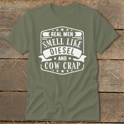 Olive green t-shirt with white text that reads "Real Men Smell Like Diesel And Cow Crap".