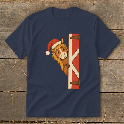 T-shirt with a cartoon horse wearing a Santa hat peeking from behind a barn door.