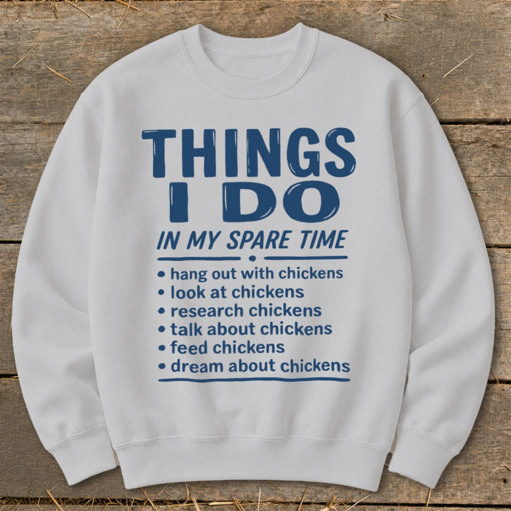 White sweatshirt with blue text "THINGS I DO IN MY SPARE TIME" and chicken activities.