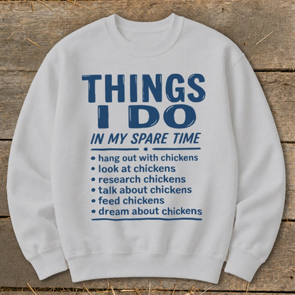 White sweatshirt with blue text "THINGS I DO IN MY SPARE TIME" and chicken activities.