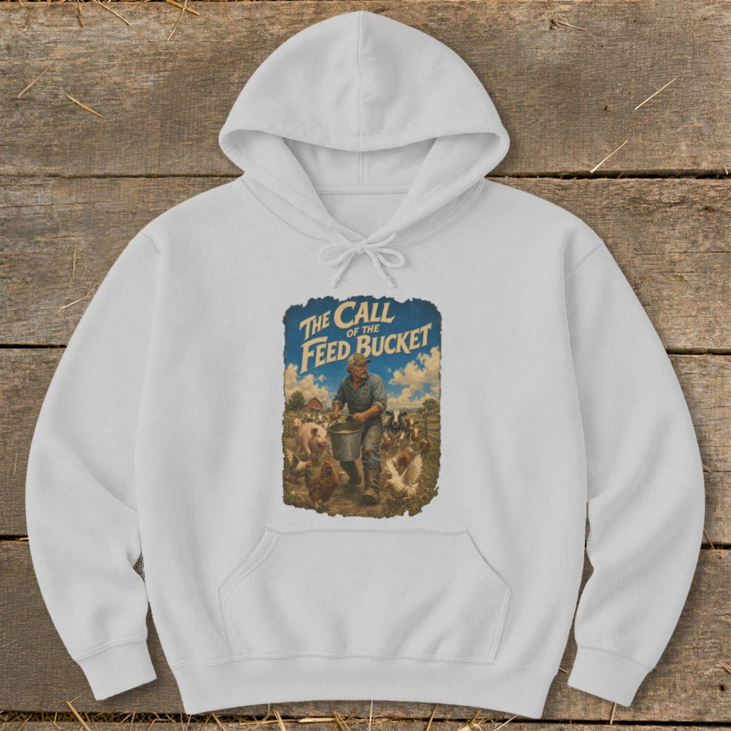 White hoodie with graphic: farmer feeding pigs and chickens, text "The Call of the Feed Bucket."