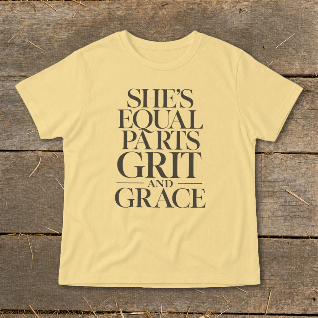 Yellow t-shirt with text "SHE'S EQUAL PARTS GRIT AND GRACE"