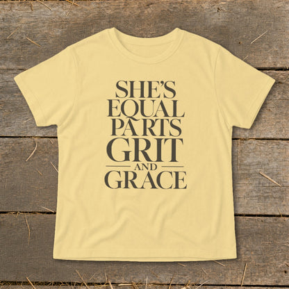 Yellow t-shirt with text "SHE'S EQUAL PARTS GRIT AND GRACE"