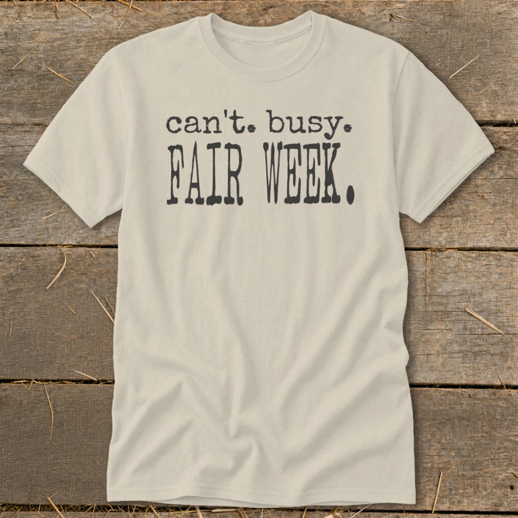 Light beige t-shirt with black text "can't. busy. FAIR WEEK."