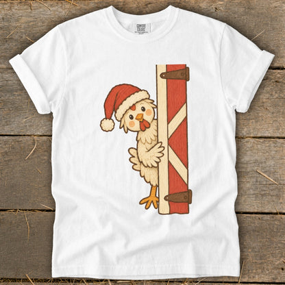 Cartoon chicken wearing a Santa hat peeks from behind a barn door.