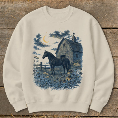 Black horse stands in a field by a barn under a crescent moon.