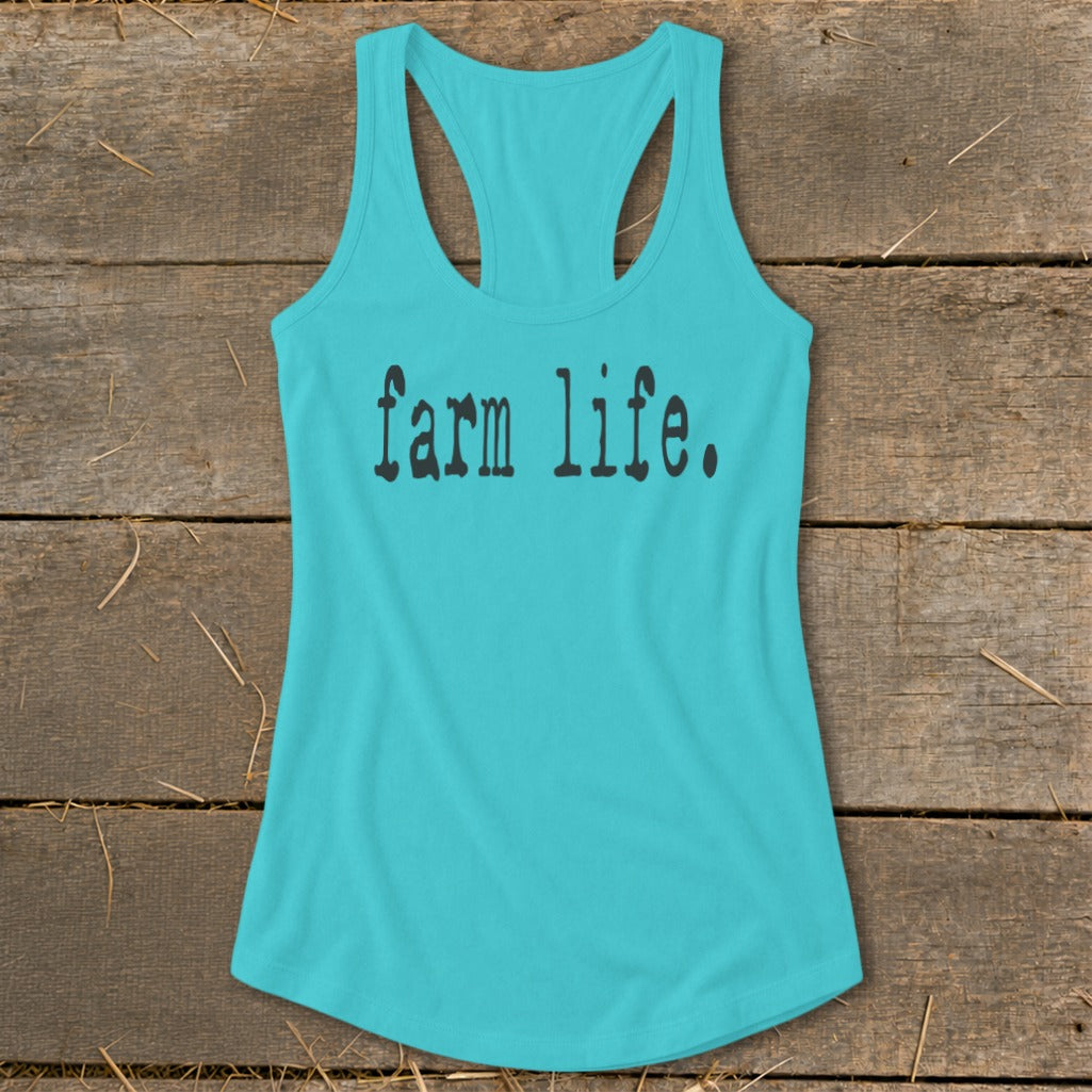 Turquoise tank top with "farm life." text on a wooden background.