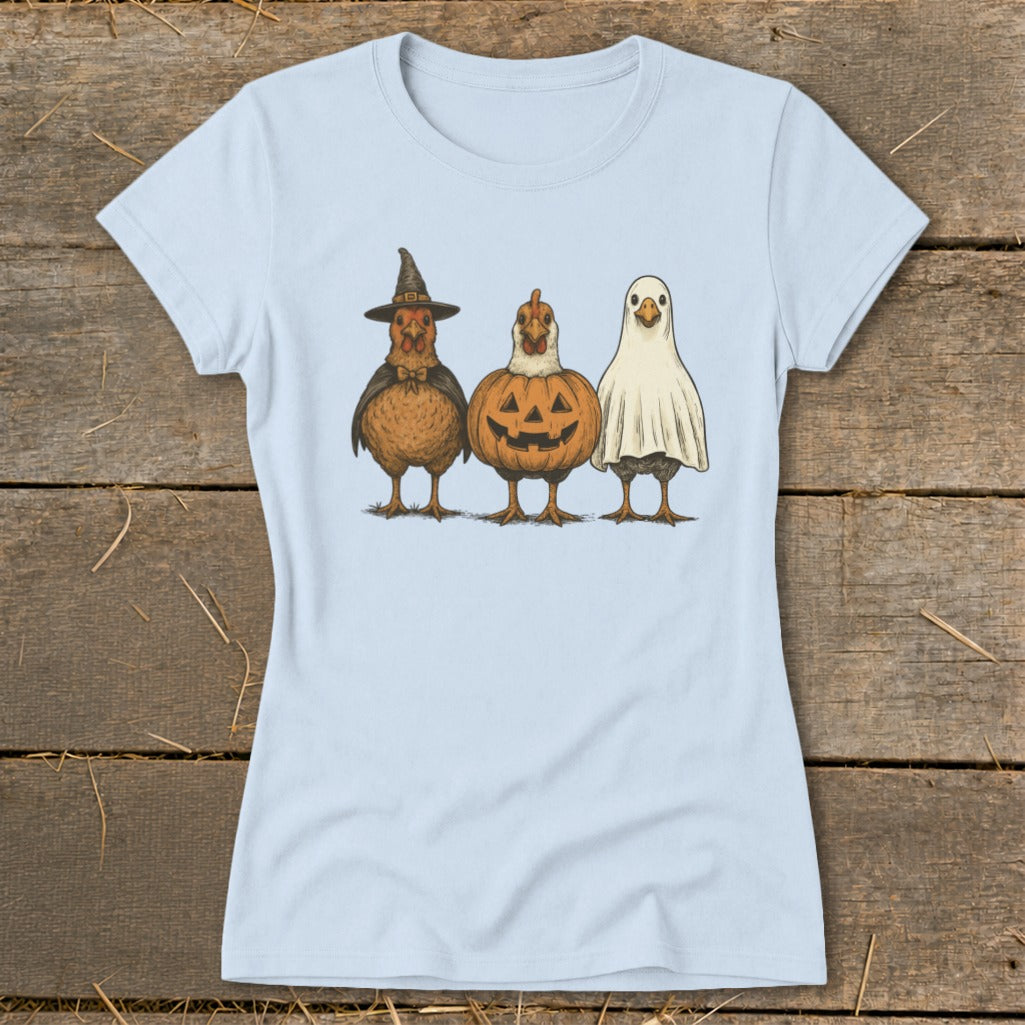 Three chickens dressed for Halloween: a witch, a pumpkin, and a ghost.
