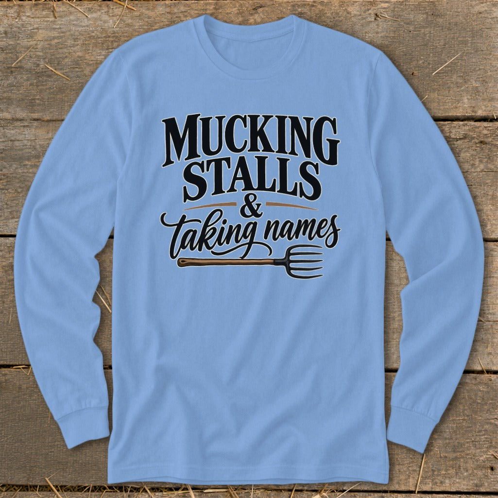 Light blue long-sleeved shirt with "Mucking Stalls & Taking Names" and a pitchfork.