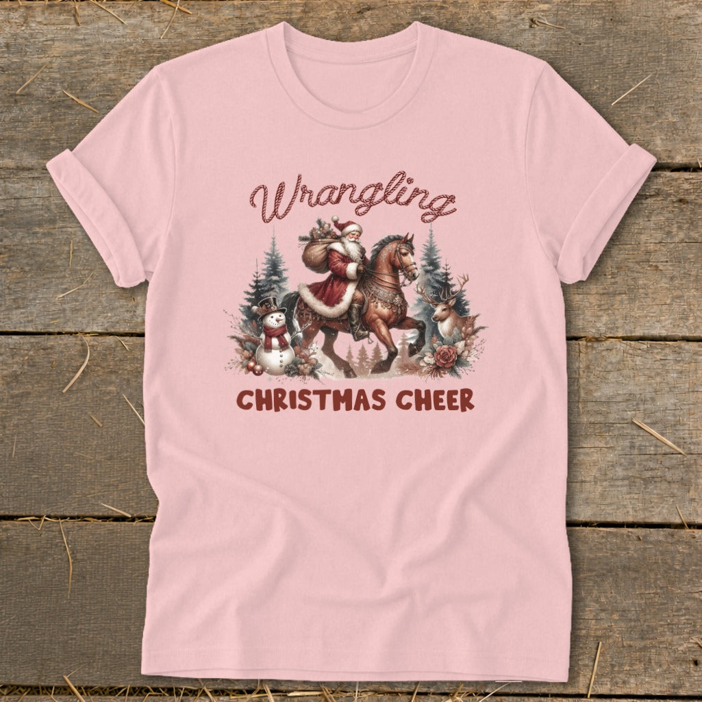 Pink t-shirt with Santa on a horse and "Wrangling Christmas Cheer" text.