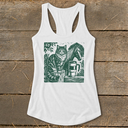 White tank top with green linocut print of cat, horse, barn, and mug.