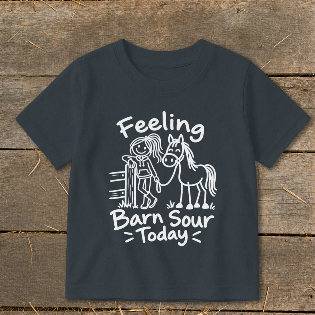 White graphic on dark shirt with text "Feeling Barn Sour Today" and drawings of a girl and horse.