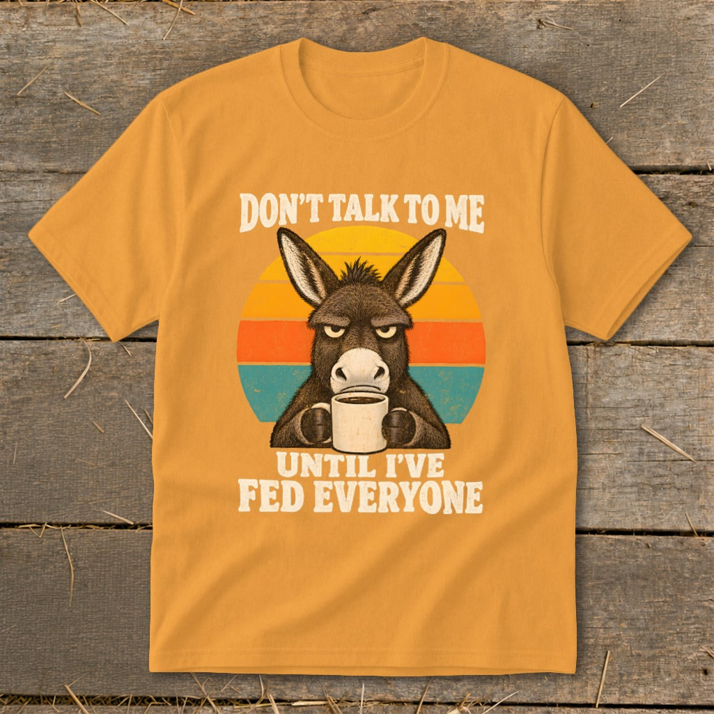 Mustard yellow t-shirt with a graphic of a grumpy donkey holding a coffee mug and retro text.