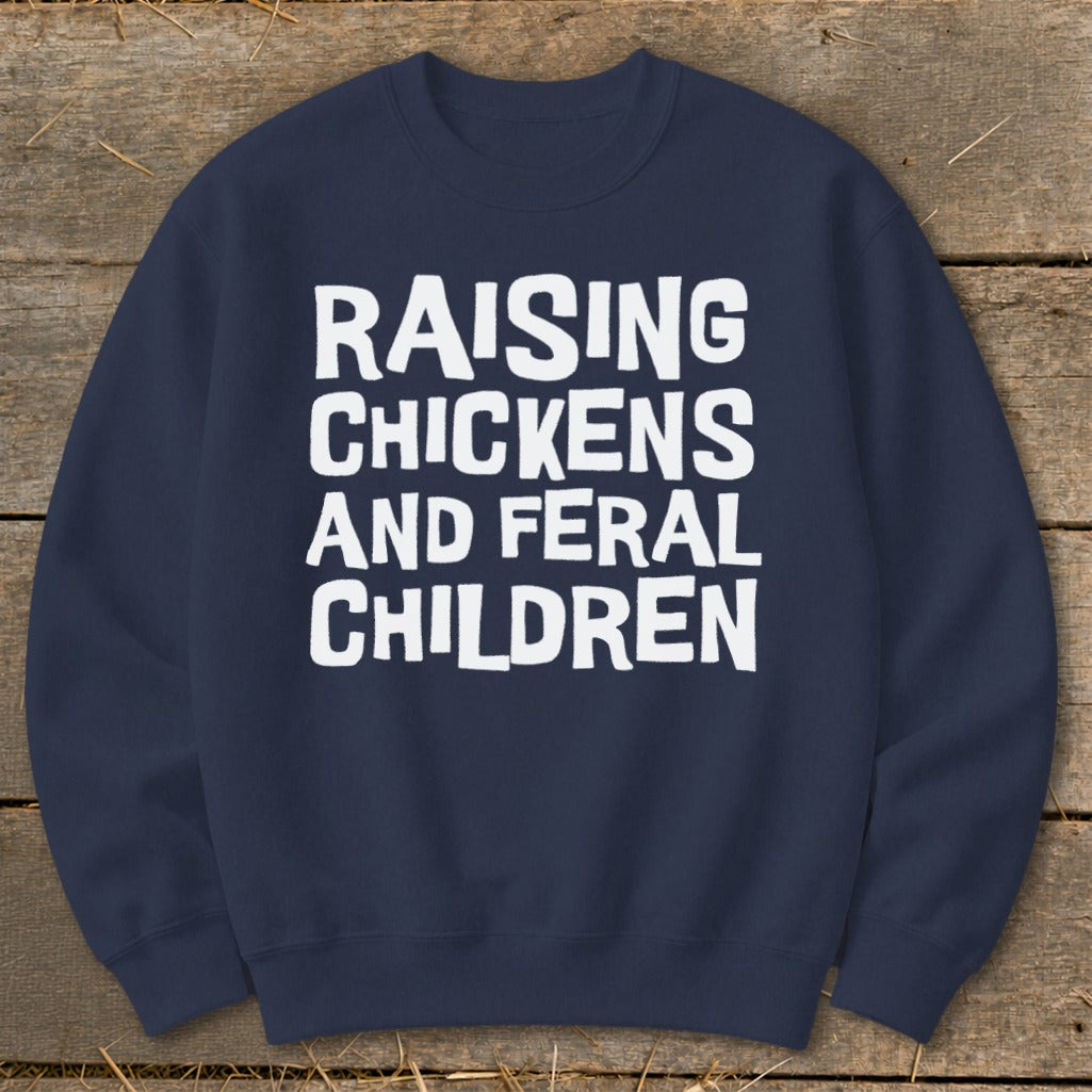 Navy sweatshirt with white text reading "Raising Chickens and Feral Children".