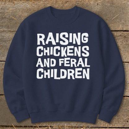 Navy sweatshirt with white text reading "Raising Chickens and Feral Children".
