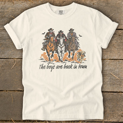 Three skeleton cowboys ride horses with text "The boys are back in town".