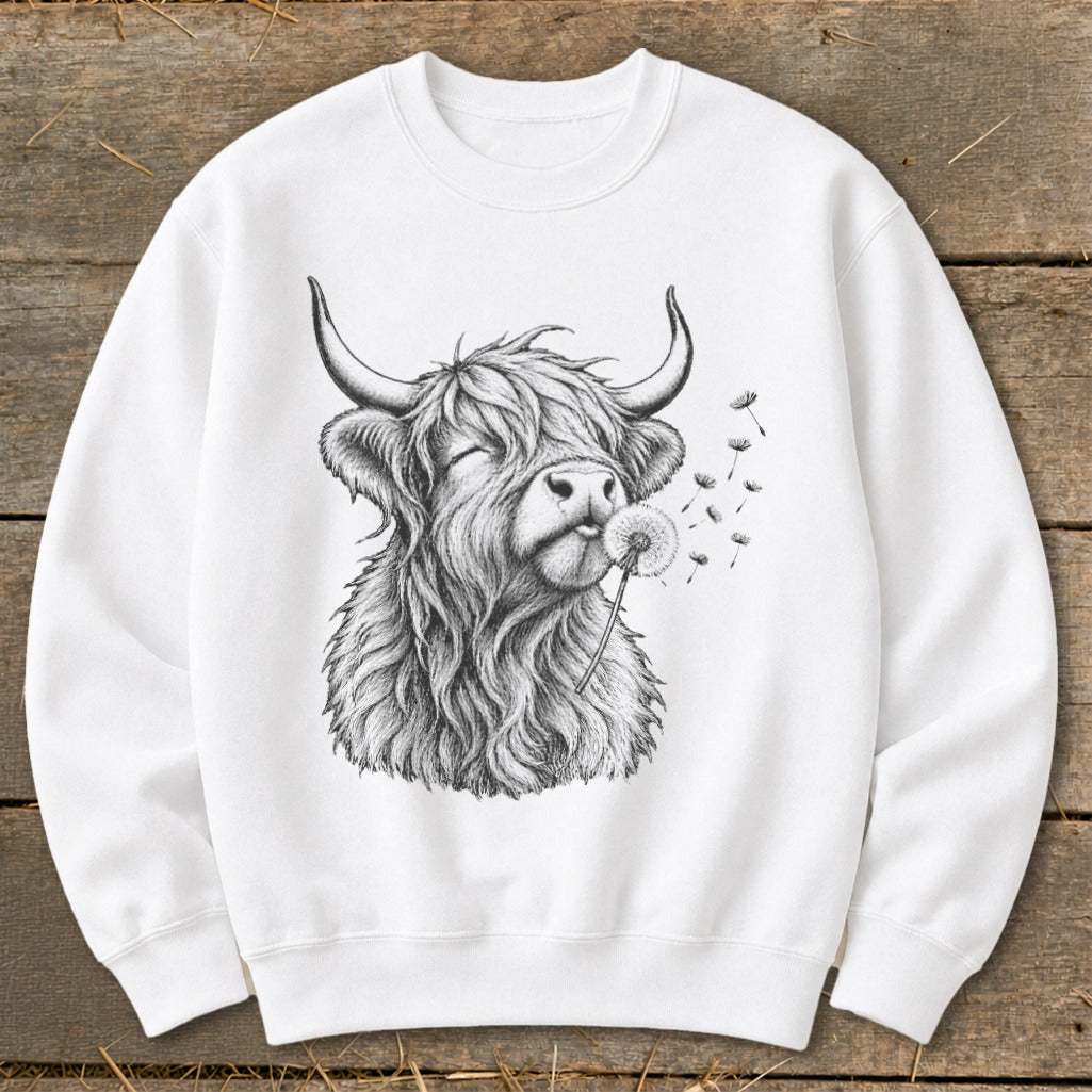 White sweatshirt with a sketch of a Highland cow blowing on a dandelion.