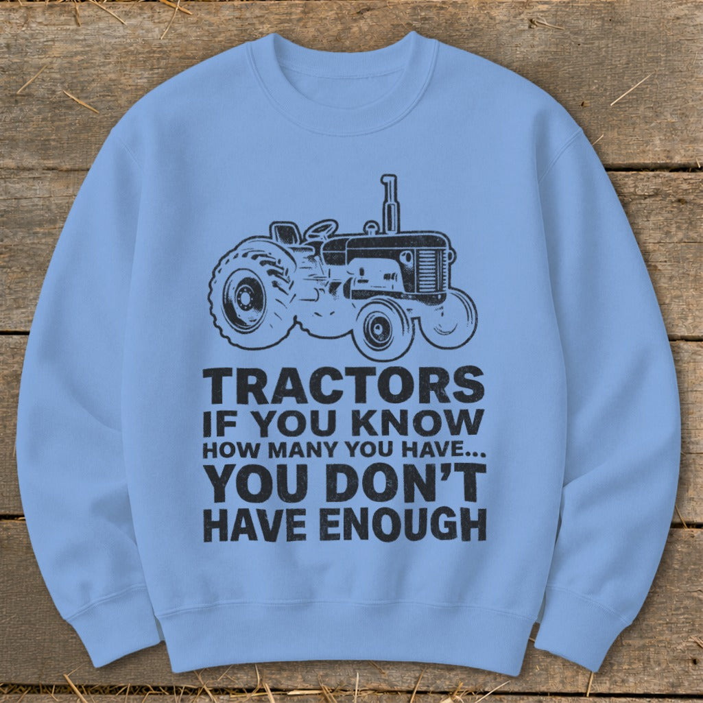 Light blue sweatshirt with a black tractor graphic and text: "TRACTORS IF YOU KNOW HOW MANY YOU HAVE... YOU DON'T HAVE ENOUGH".