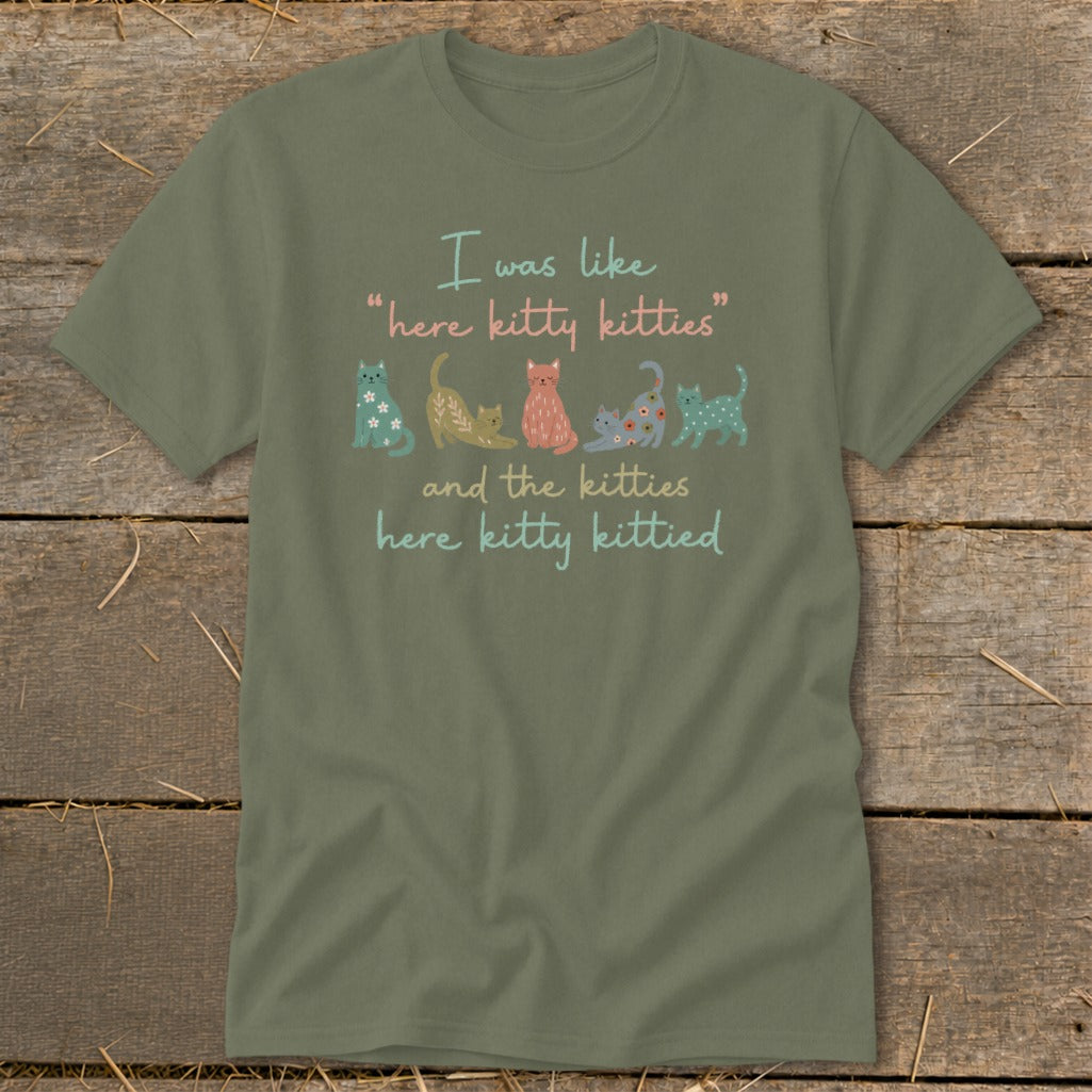 Green t-shirt with quote "I was like 'here kitty kitties' and the kitties here kitty kittied" and cat illustrations.