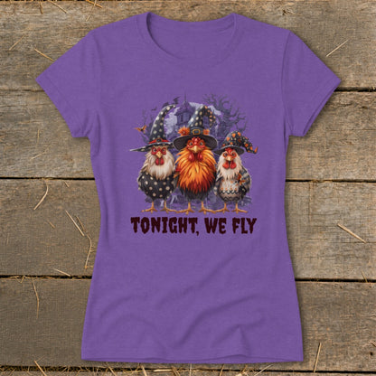 Three chickens in witch hats stand before a spooky house, with text "TONIGHT, WE FLY".