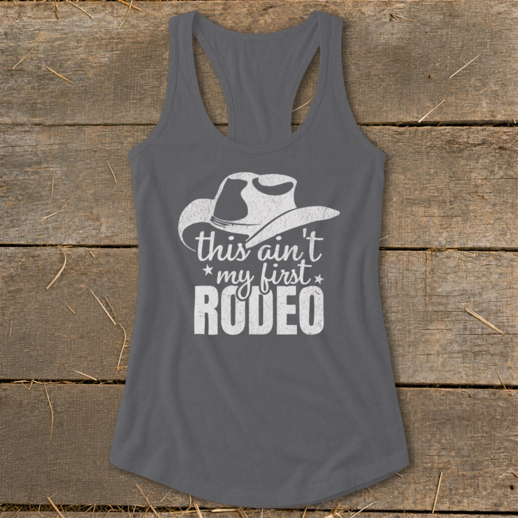 Gray tank top with white cowboy hat graphic and "this ain't my first RODEO" text.