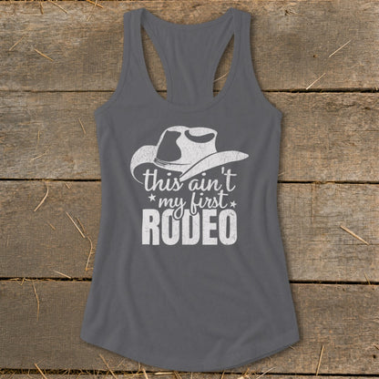 Gray tank top with white cowboy hat graphic and "this ain't my first RODEO" text.